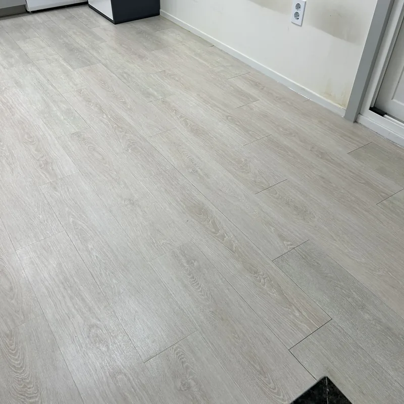데코타일 작업 후, 나무결 무늬 데코타일로 마감된 같은 공간의 바닥