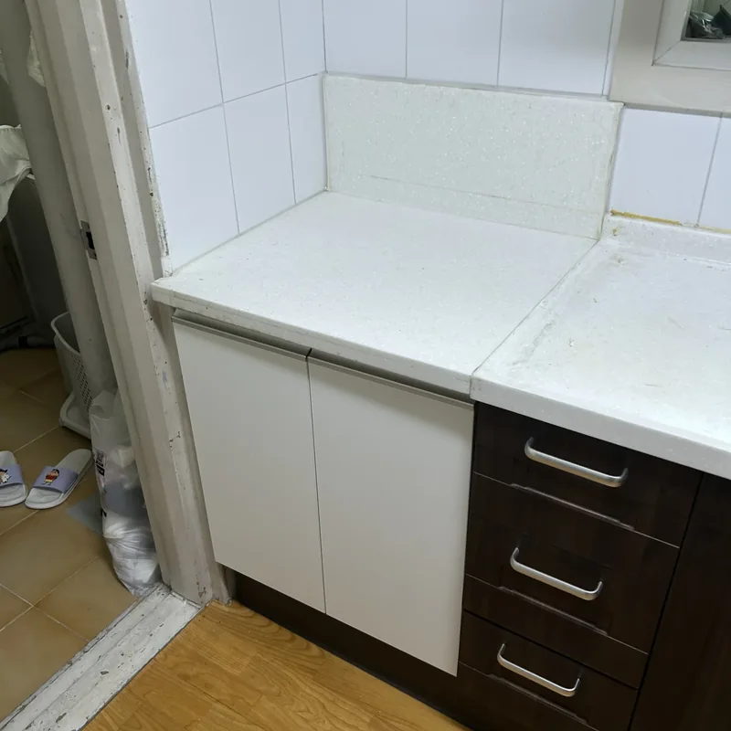 싱크대교체 작업 후, 흰색 문짝 하부장으로 바뀐 같은 주방 코너